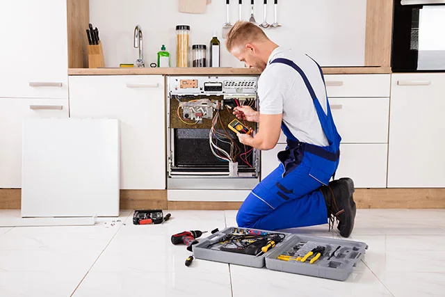Appliance technician inspecting a residential oven in a Port Charlotte kitchen
