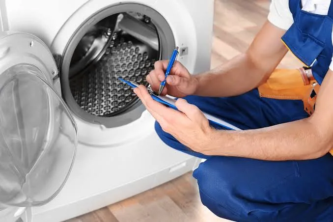Technician documenting a household appliance inspection