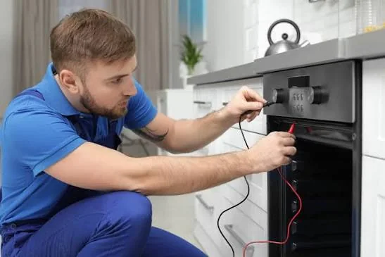Technician testing the controls of a residential oven and range